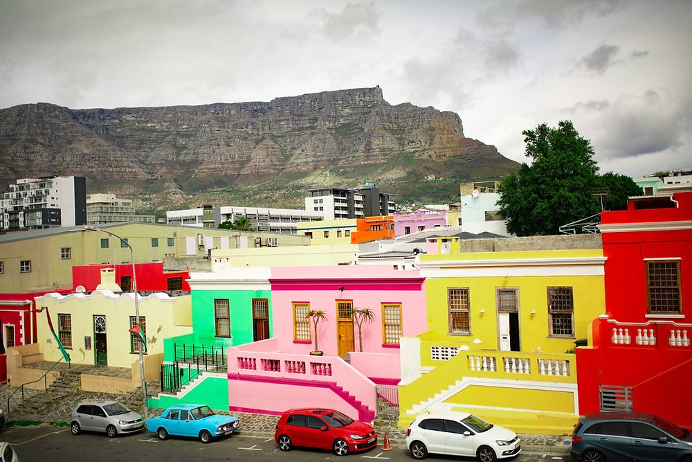 Bo-Kaap is a vibrant and colorful neighborhood located on the slopes of Signal Hill. The area is known for its brightly painted houses, steep cobblestone streets, and rich cultural heritage